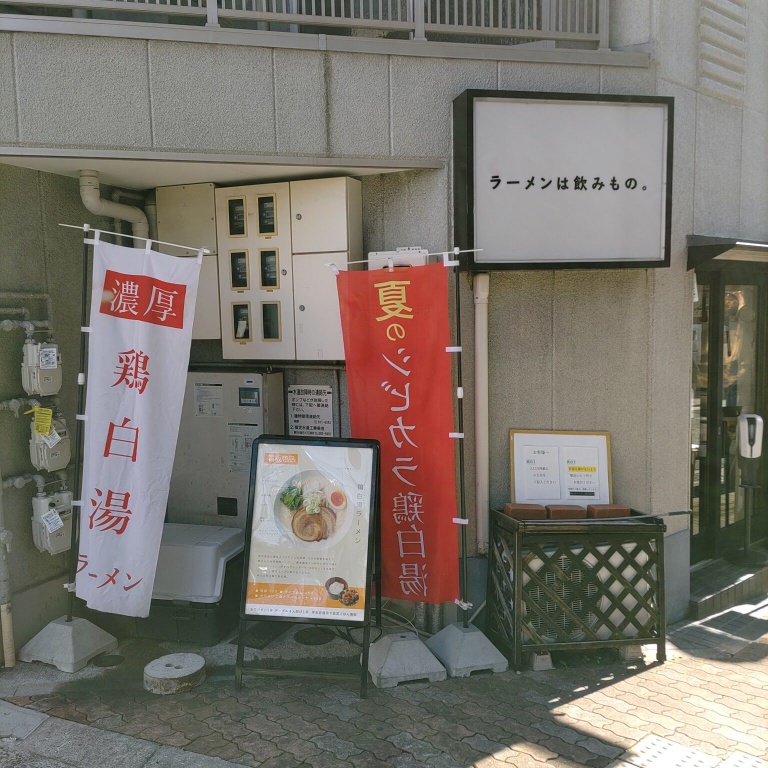 鶏白湯ラーメンMUTSUKIの店先の様子。ラーメンは飲みもの。という看板が出ている。