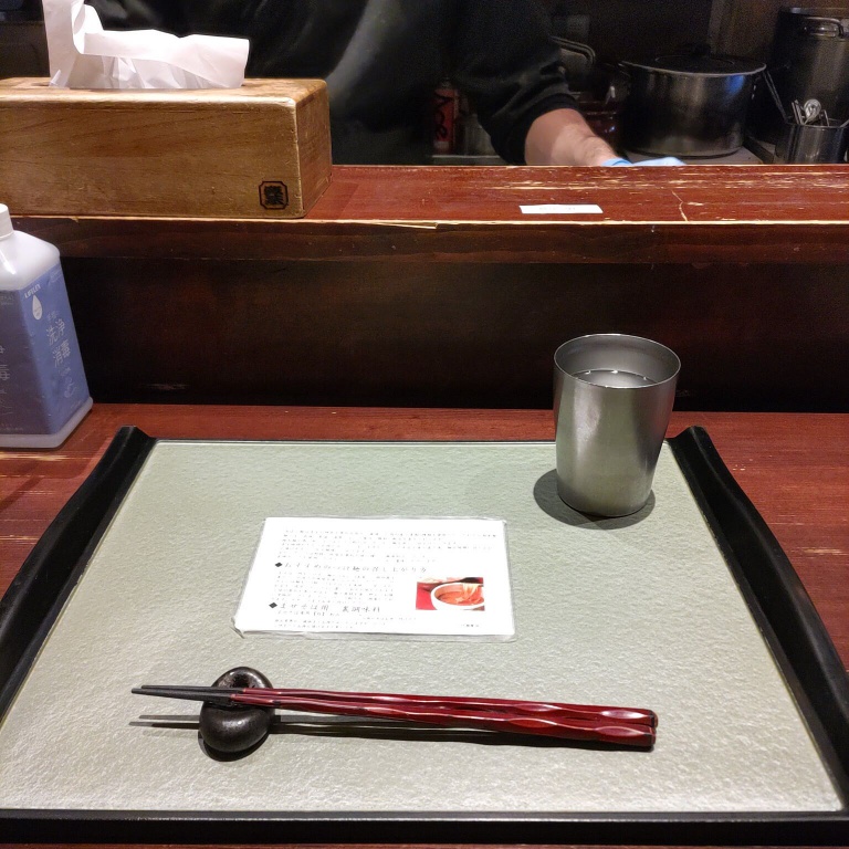 席に着くと、つけ麺を乗せるお盆に箸とお水が置かれてある。