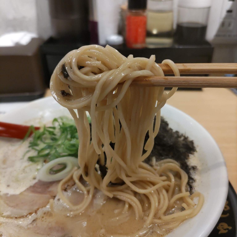 麺道しゅはり六甲道店の鶏白湯ラーメンを箸で持ち上げた様子