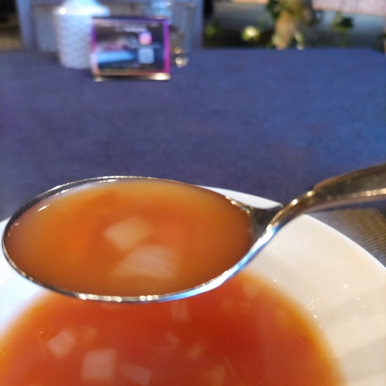 スープをスプーンで掬った