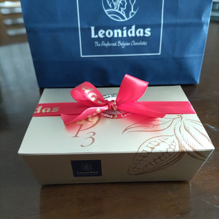 レオニダスの外箱。金色のパッケージに赤色のリボンが掛かっている。